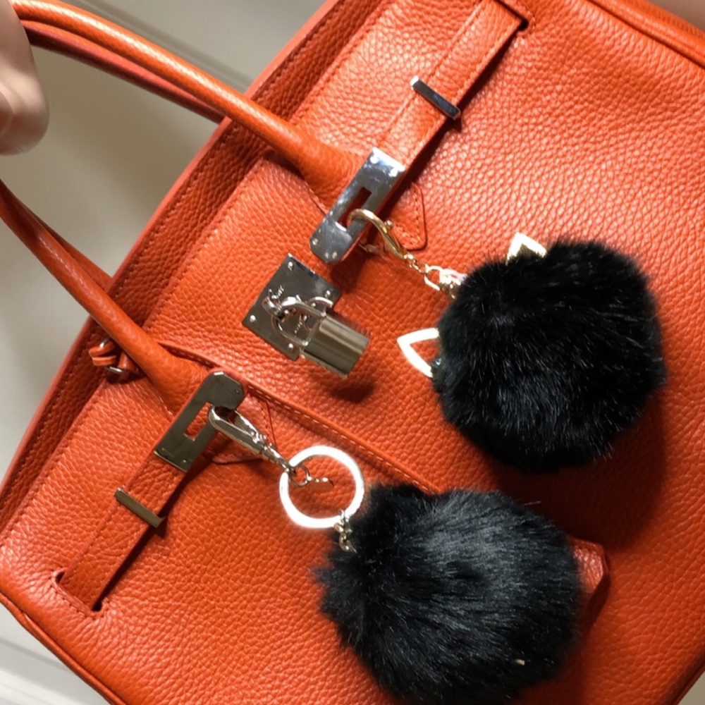 Chic Orange Shoulder Bag with Black Pom Accents